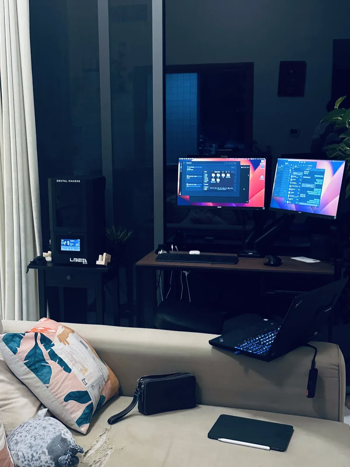 Bureau à domicile à Dubaï, la nuit, deux écrans sur la table de travail