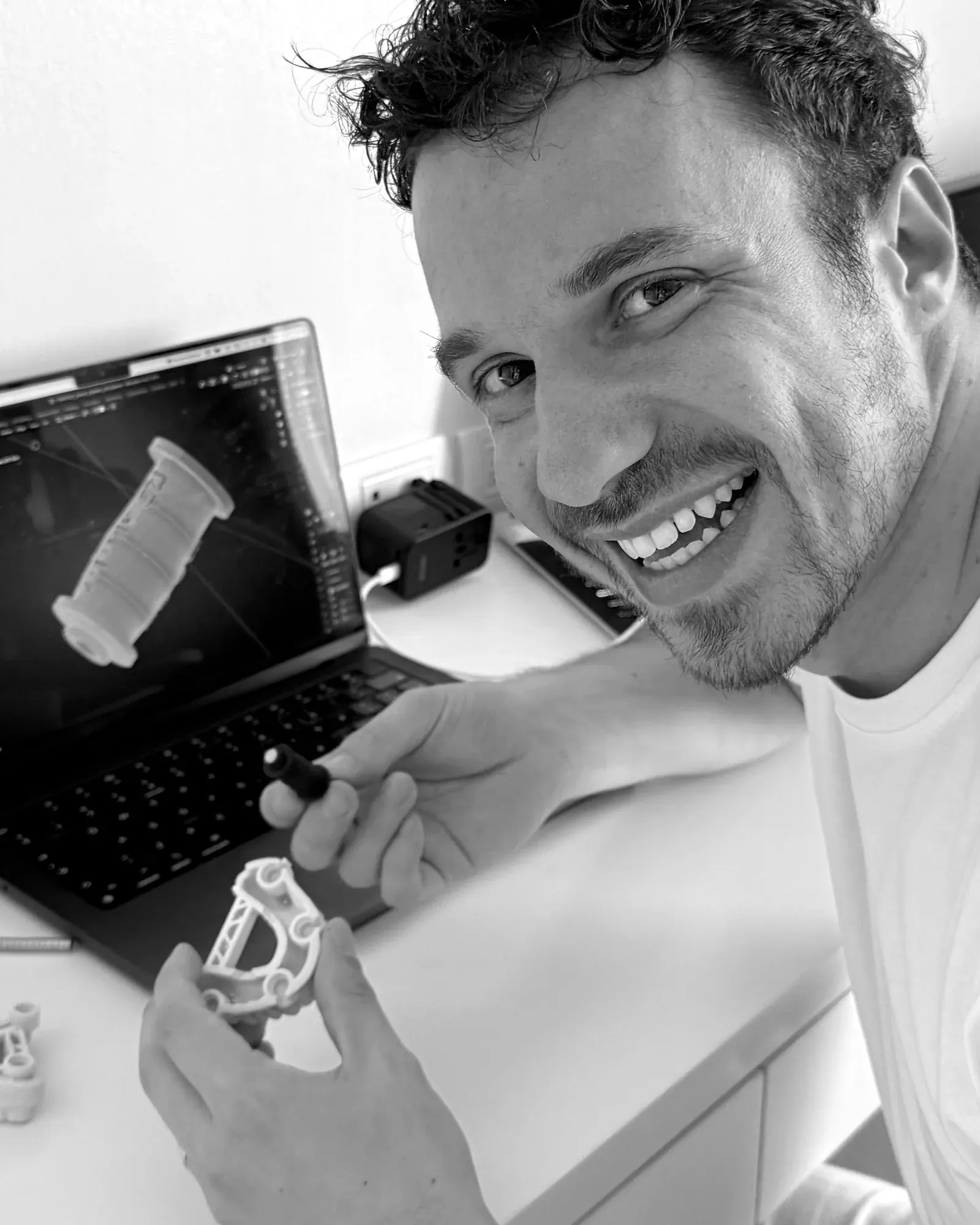 Photo en noir et blanc d’Antonello Croce à son bureau avec le premier prototype de l’outil de placement des aimants