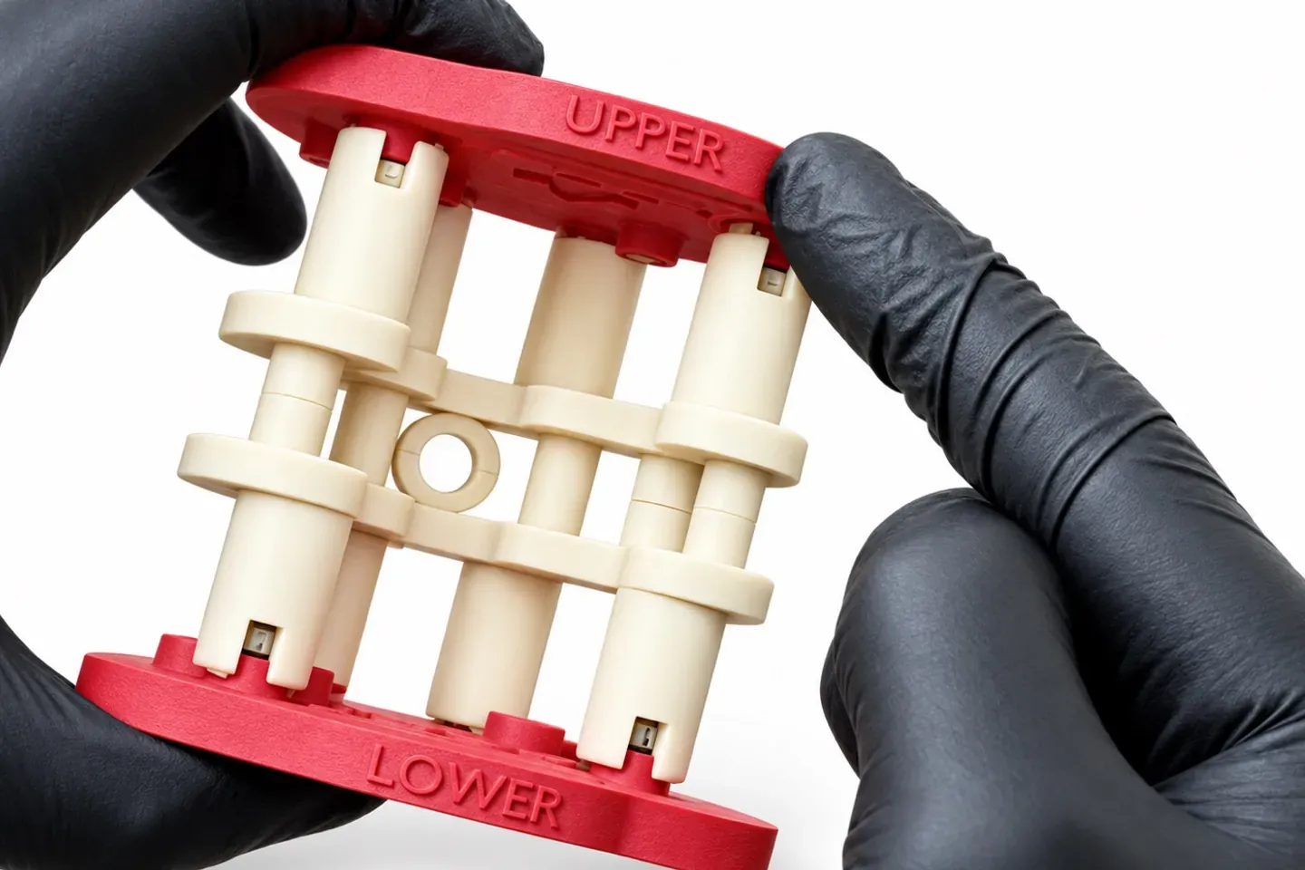 Mains gantées tenant le bloc calibrateur entre les plaques Flex marquées UPPER et LOWER
